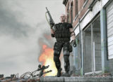 Ausschnitt einer Szene des Spiels Ego-Shooter. Mann steht in schusssicherer Kleidung mit erhobenem Maschinengewehr.