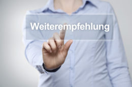 Frau tippt mit ihrem Finger auf Kästchen "Weiterempfehlung".