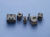Schwaze Buchstaben, die das Wort "Monica" ergeben, vor einem blauen Hintergrund.