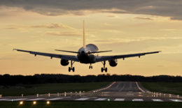 EIn Flugzeug befindet sich während eines Sonnenuntergangs im Landeanflug.