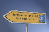 Gelbes richtungsweisendes Schild mit der Aufschrift "Europäischer Gerichtshof für Menschenrechte".