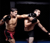Ein Boxer schlägt seinem Gegner mit schwarzen Boxerhandschuhen ins Gesicht.