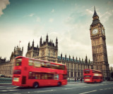 roter Doppeldecker Bus in London, der gerade an dem Londoner Wahrzeichen "Big Ben" vorbeifährt