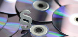 Paragraphenzeichen mit CDs im Hintergrund