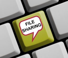 Gelbe Taste mit einer Sprechblase "Filesharing", die sich innerhalb einer grauen Tastatur befindet