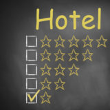 Tafel mit der gelben Überschrift "Hotel" mit einer Skala zur Vergabe der Anzahl an Sternen, Haken bei einem Stern