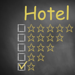 Tafel mit der gelben Überschrift "Hotel" mit einer Skala zur Vergabe der Anzahl an Sternen, Haken bei einem Stern