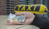 Mann legt Hand mit Geld auf Taxi-Autodach