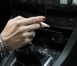 Frau raucht während dem Autofahren