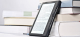 E-Book-Reader steht vor mehreren Büchern