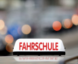 Fahrschulenzeichen auf einem Autodach im Straßenverkehr