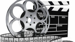 Filmrolle und Filmband, dahinter Filmklappe