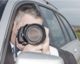Fotograf fotografiert mit seiner Kamera aus einem Auto heraus