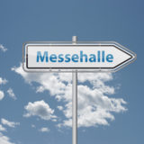 Schild mit der Aufschrift "Messehalle" vor blauem Himmel