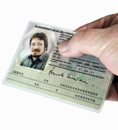 Hand hält Personalausweis mit Passfoto