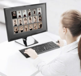 Frau sitzt vor dem PC und schaut sich Bilder von Frauen an.