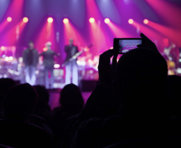 EIne Person macht mit ihremHandy eine Aufnahme von einem Konzert.