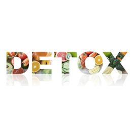 Detox Schriftzug bestehend aus verschiedenem Obst und Gemüse vor einem weißen Hintergrund.