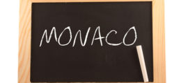 "Monaco" als Schriftzug mit weißer Kreide auf eine schwarze Tafel geschrieben.