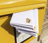 Briefkasten mit einem Stapel Briefe