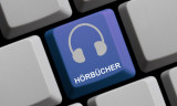 graue Computer-Tastatur mit einer blauen Taste auf der Kopfhörer zu sehen sind, und auf der steht "Hörbücher"