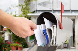 Mann, der Brief aus Briefkasten nimmt