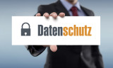 Jemand hält ein Schild mit der Aufschrift "Datenschutz" in der Hand.