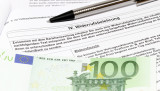 Widerrufsbelehrung, auf der ein Hundert-Euro-Schein liegt