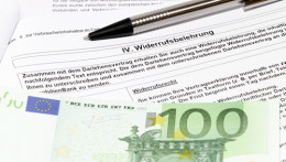 Widerrufsbelehrung, auf der ein Hundert-Euro-Schein liegt
