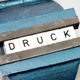 Schriftzug "Druck" symbolisiert Drucksituation