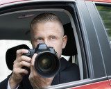Ein Paparazzo sitzt im Auto und fotografiert mit seiner Kamera