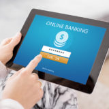 Eine Frau greift mittels Tablet auf Online Banking zu