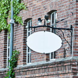 ein weißes Schild ist an einer Hauswand angebracht