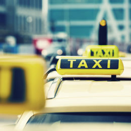 Taxis stehen in einer Reihe; zu erkennen sind sie an ihren TAXI-Schildern