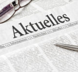 Zeitschriftenrubrik "Aktuelles" mit Kugelschreiber und Brille.