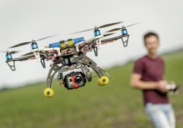 junger Mann fliegt eine ferngesteuerte Drohne mit einer Kamera