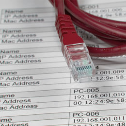 Kabel liegt auf einem Blatt, auf dem IP-Adressen notiert sind