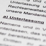 Dokument mit Fokus auf dem Wort "Unterlassung", Unterlassungsklage