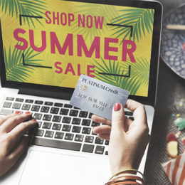 Online-Shopping im Summer Sale mit einer silbernen Platinum-Kreditkarte.