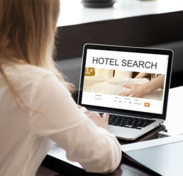 Frau sucht ein Hotel über das Internet an ihrem Laptop