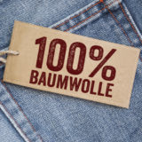 Jeans mit Anhänger, Label, auf dem 100% Baumwolle steht