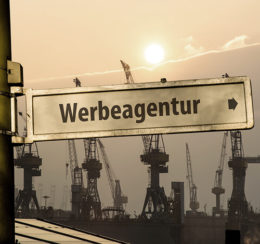 Wegweiser in Industriegebiet zeigt Richtung Werbeagentur