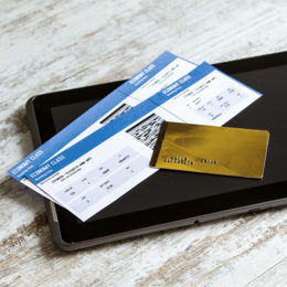 Flugtickets und goldene Kreditkarte auf einem Tablet