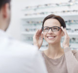 Frau im Optikergeschäft probiert Brille