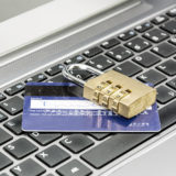Kreditkarte liegt unter einem Zahlen-Vorhängeschloss auf einer Tastatur; Online-Banking
