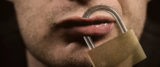männliche Lippen die durch ein Vorhängeschloss verschlossen werden, Einschränkung der Redefreiheit