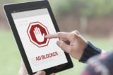 Mann hält Tablet mit Logo für Adblocker