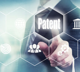 Geschäftsmann steht an einer digitalen Wand und berührt den Button mit der Aufschrift "Patent"