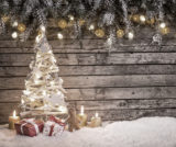 ein Weihnachtsbaum mit Geschenken vor hölzernem Hintergrund