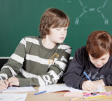 Schüler in der Schule schreibt während einer Arbeit ab